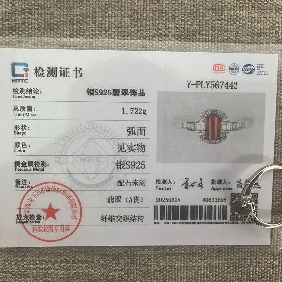 Red jadeite ring beside its matching NGTC certificate on a woven background.