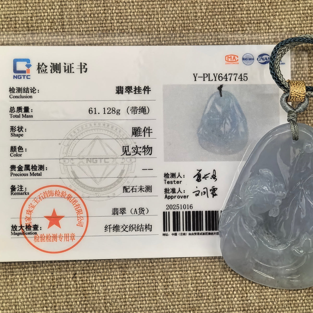 Blue-lavender jadeite Lotus and Fish Pendant with its braided cord beside the matching NGTC certificate.