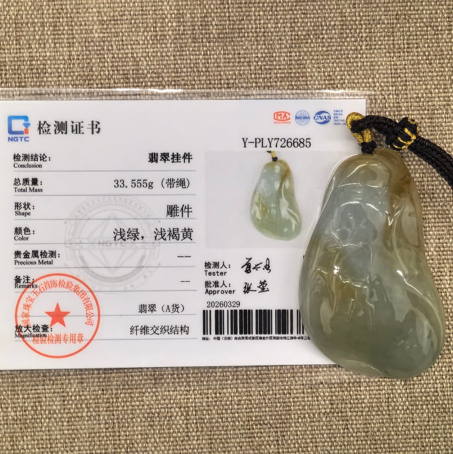 NGTC certified yellow-green deer jadeite pendant shown with matching certificate and cord.