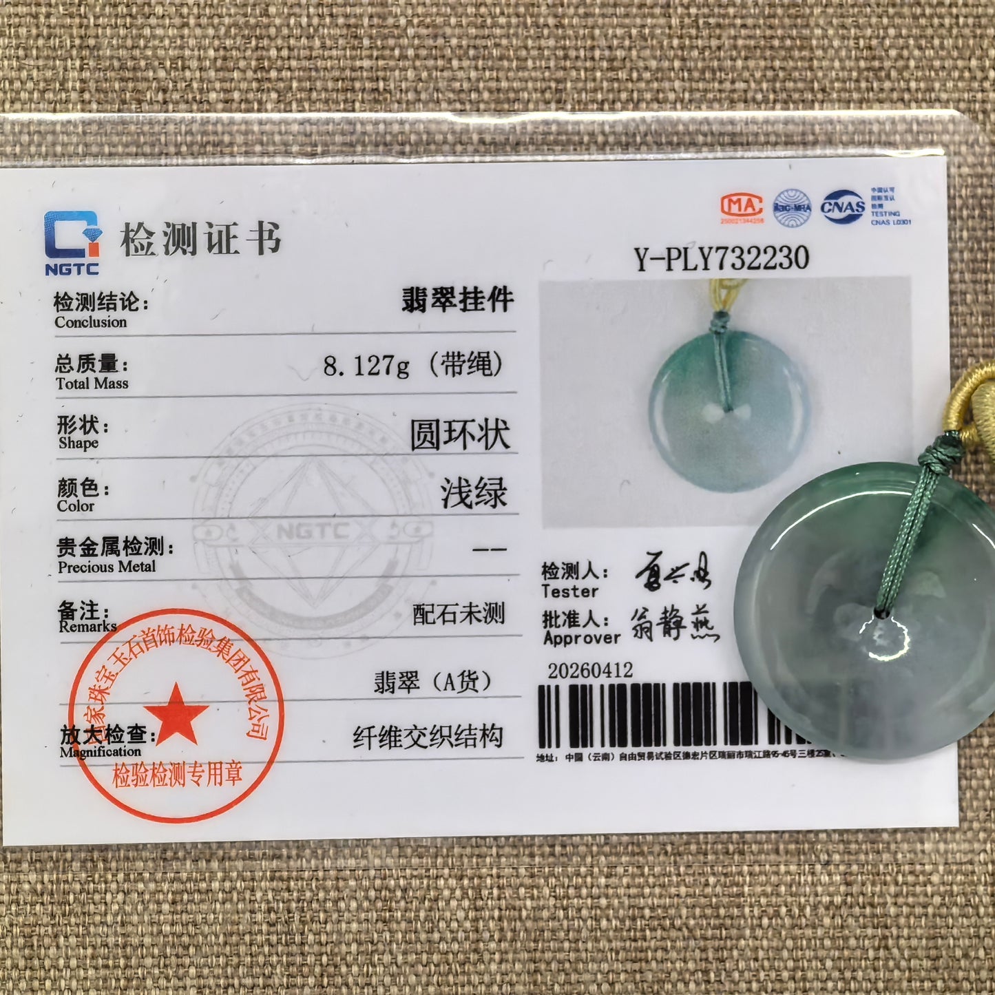 NGTC certified icy glutinous floating green Peace Buckle jadeite pendant shown with matching certificate and cord.