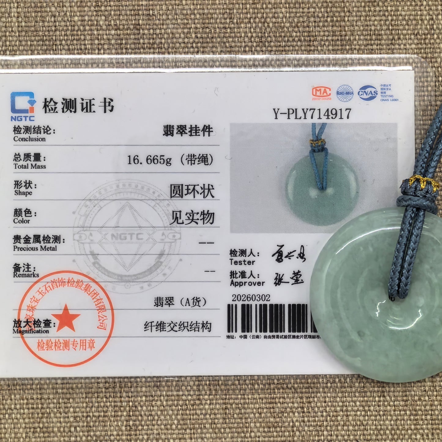 NGTC certified glutinous pale green Peace Pendant jadeite pendant shown with matching certificate.