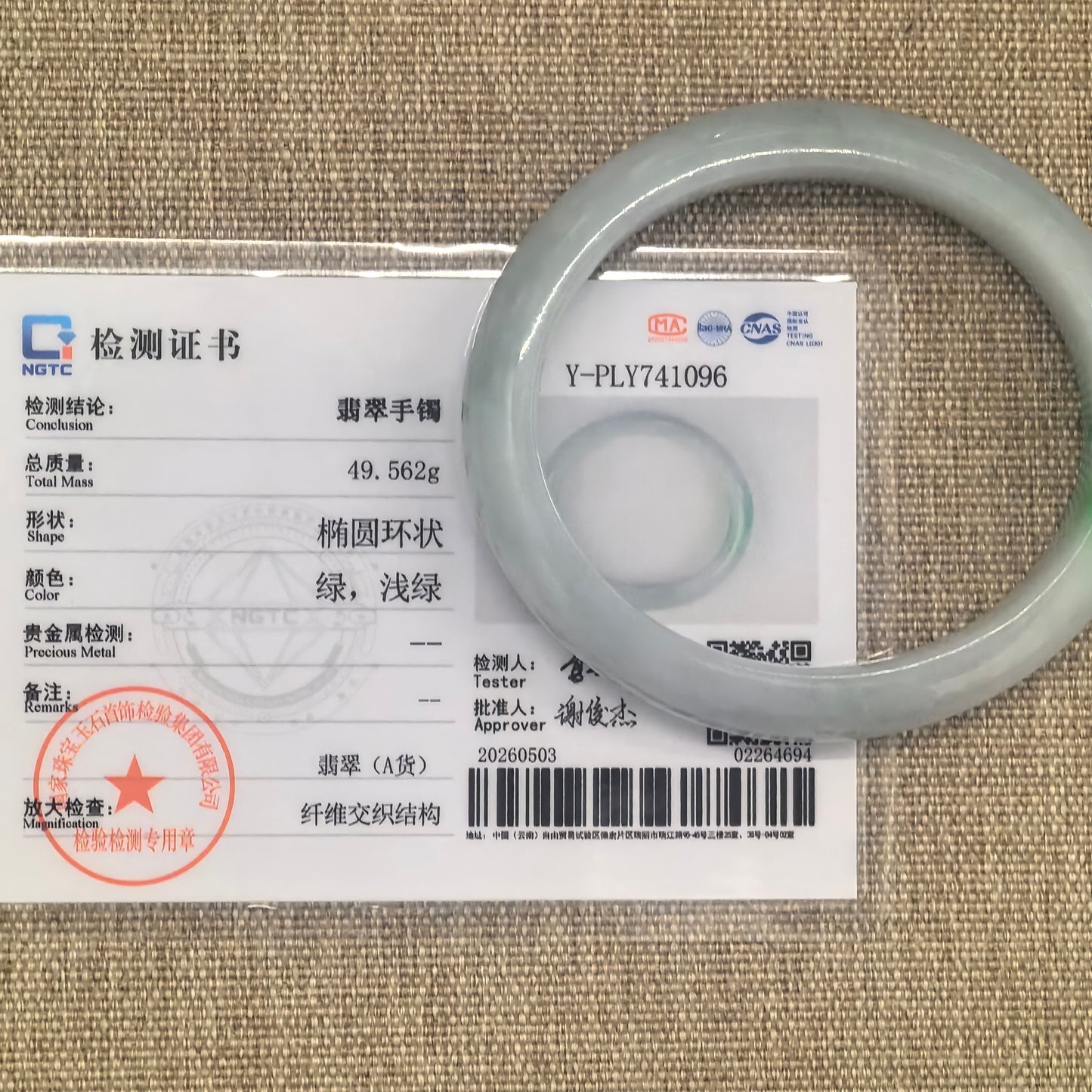 NGTC certified glutinous white green oval jadeite bangle shown with matching certificate.