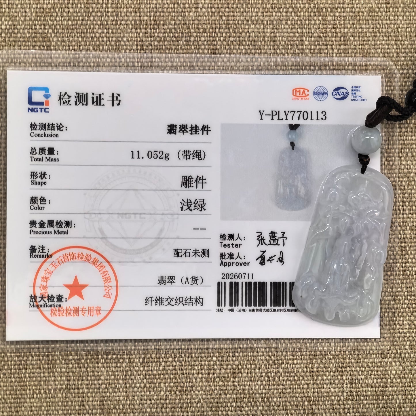 NGTC-certified icy-glutinous Guanyin jadeite pendant displayed with its matching authentication certificate.