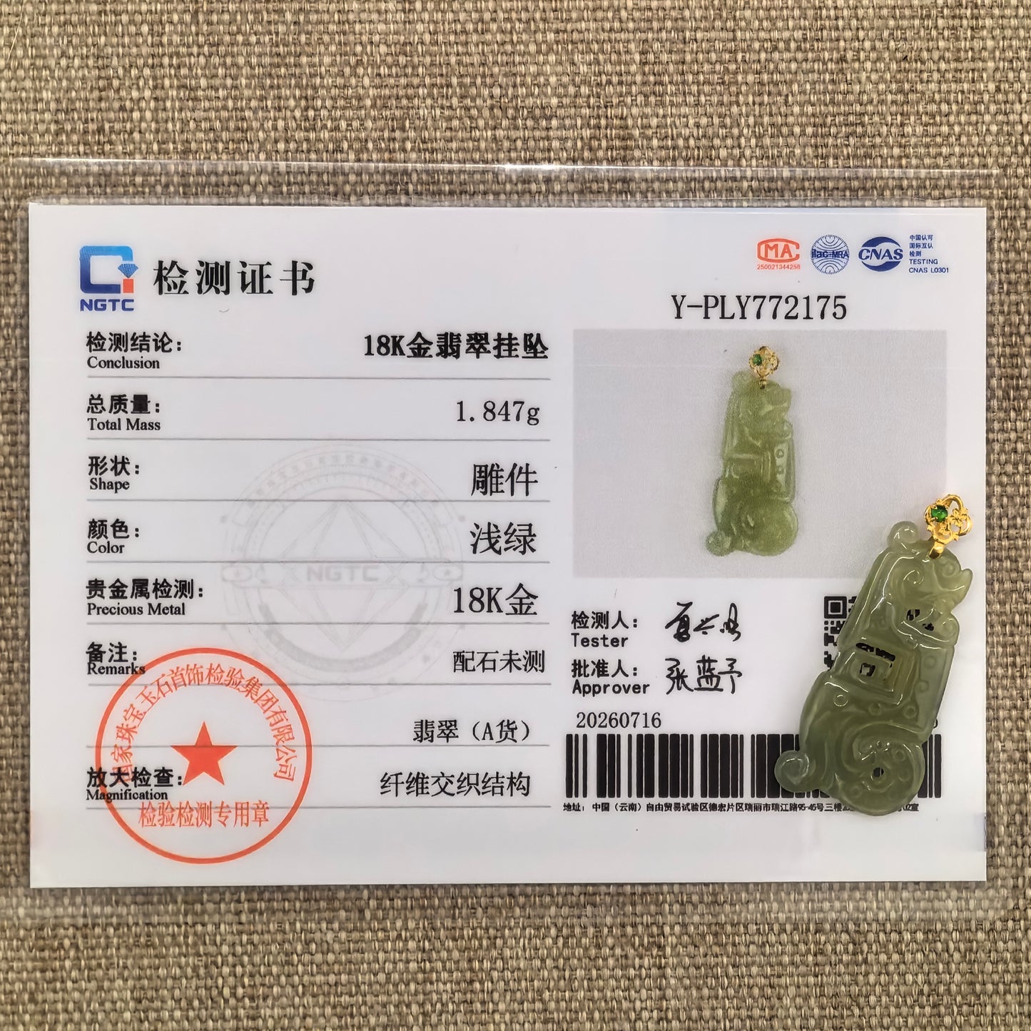 Detailed front view of the yellow-green jadeite pendant showing the curled Kui dragon motif and geometric carving.