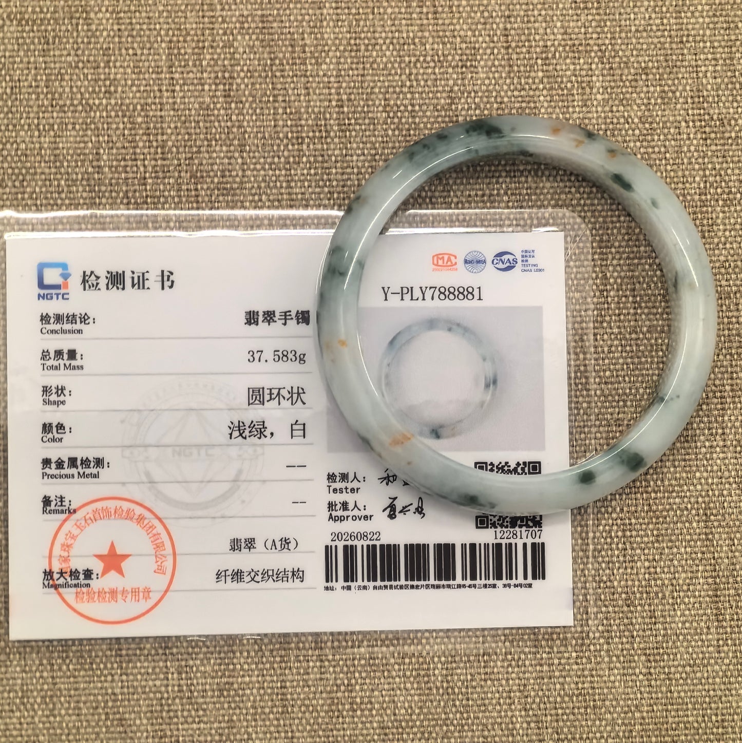 NGTC certified Natural Grade-A fine glutinous milk white jadeite D-shape bangle with green floating flower and golden flecks shown with certificate.
