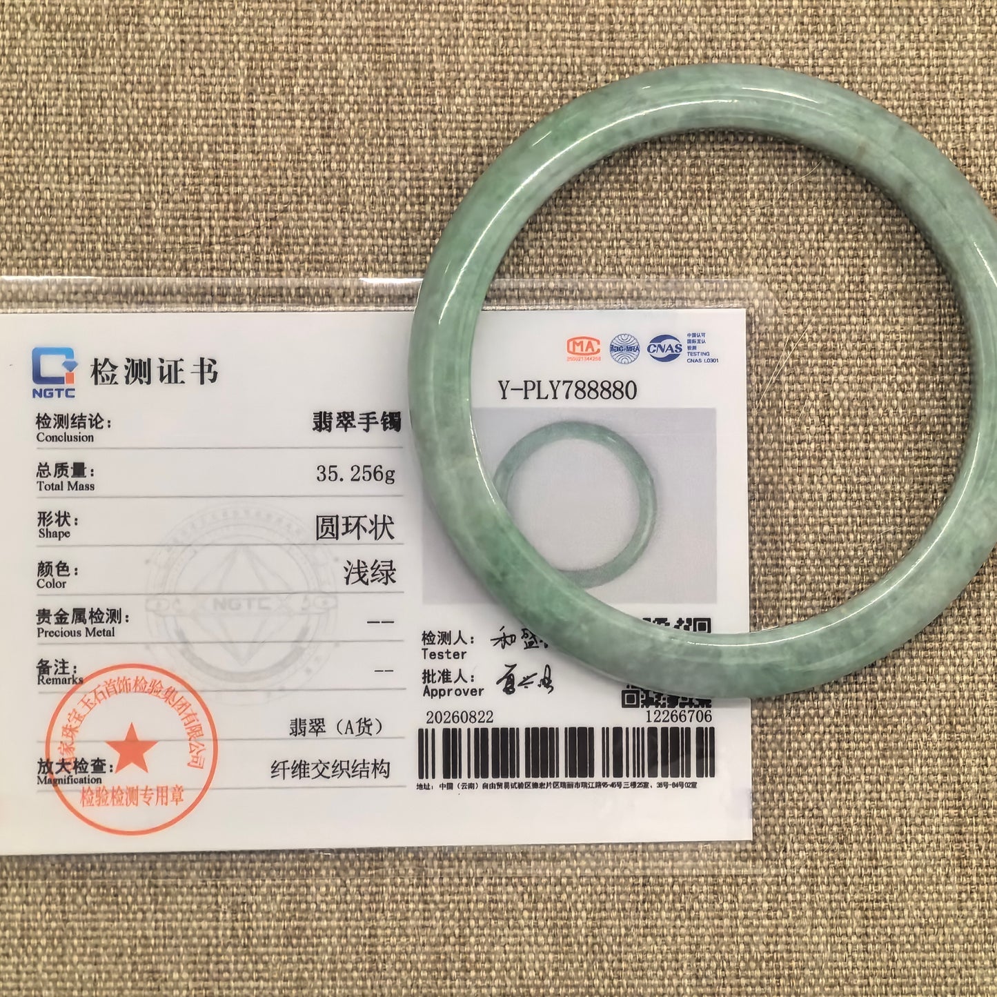 NGTC certified Natural Grade-A bean-glutinous apple green D-shape jadeite bangle shown with its matching certificate.