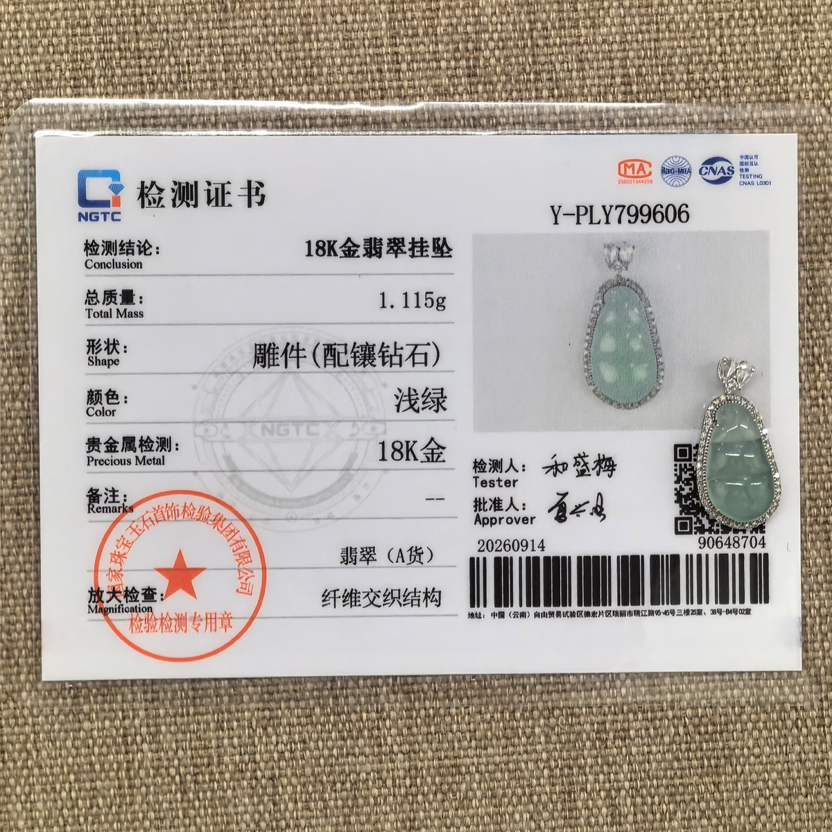 Light green jadeite bean pod pendant in an 18K gold and diamond setting displayed beside its matching NGTC certificate on a woven background.
