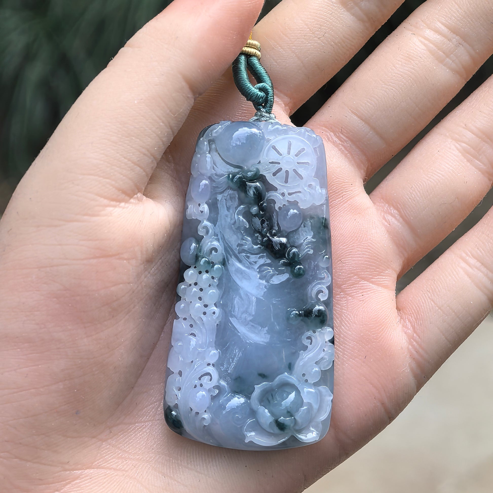 Handheld natural Grade-A Burmese jadeite lotus dragon pendant showing large statement size and blue-purple color