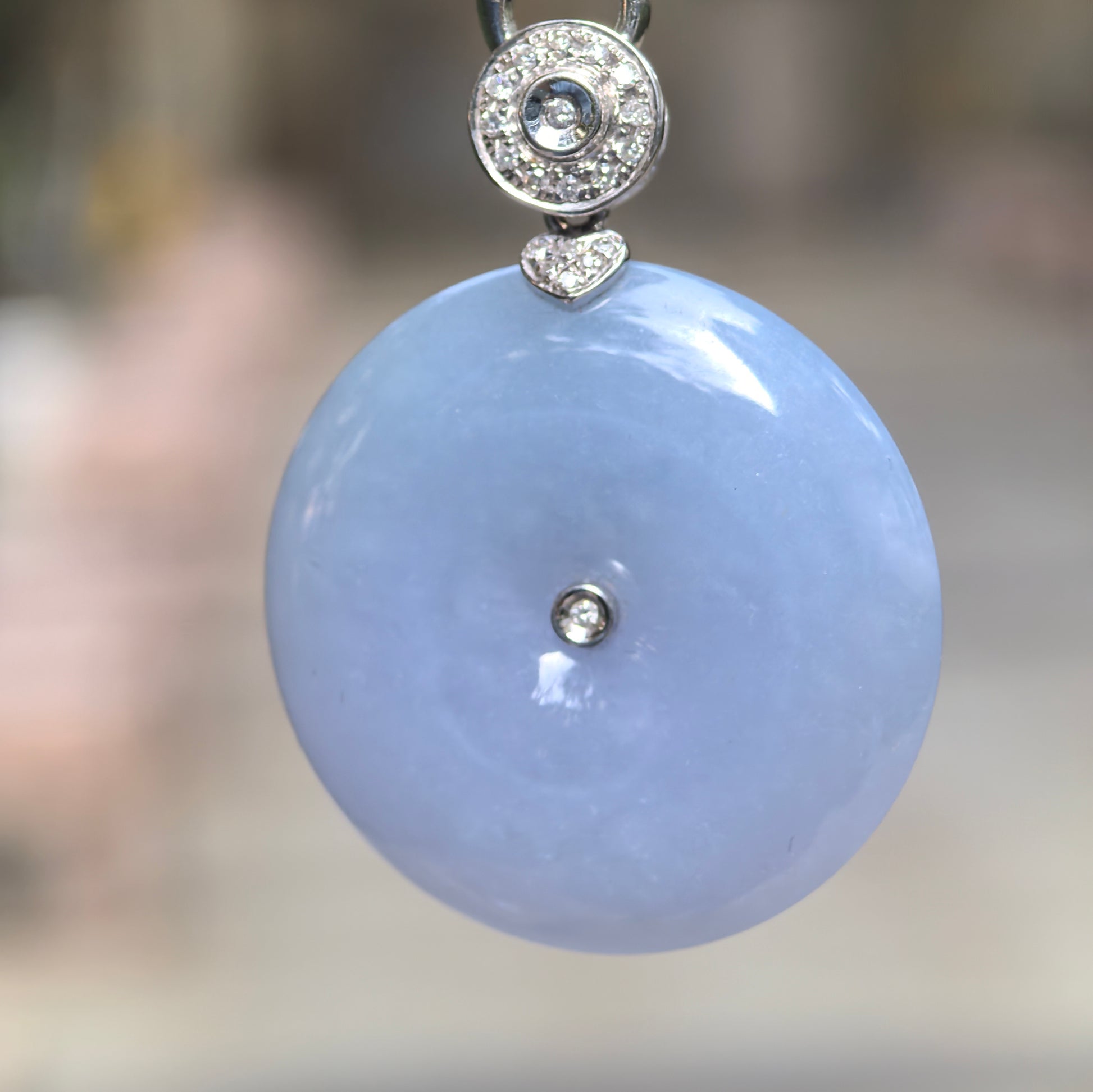 Close-up of purple Peace Pendant jadeite pendant showing rich color, smooth domed surface, and diamond-accented setting.
