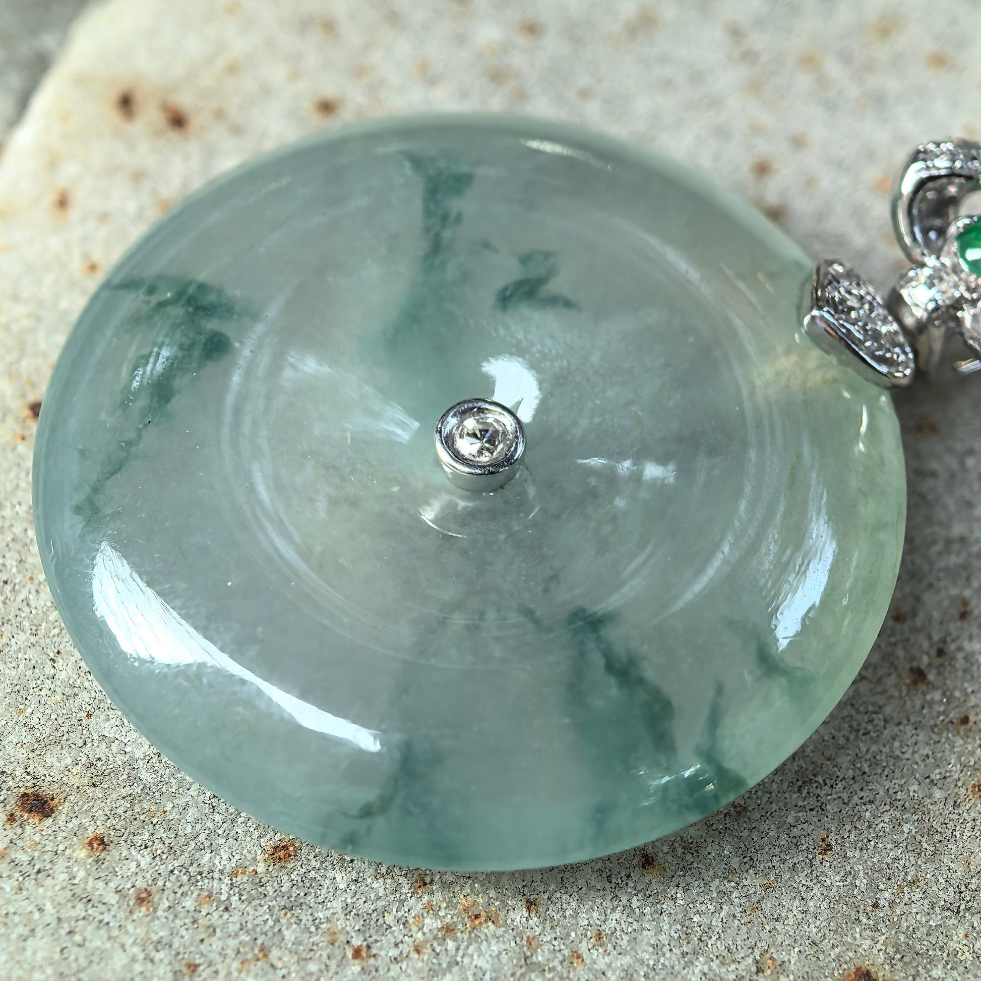 Close-up of icy glutinous floating green Peace Pendant jadeite showing lively green patterns and smooth polish.