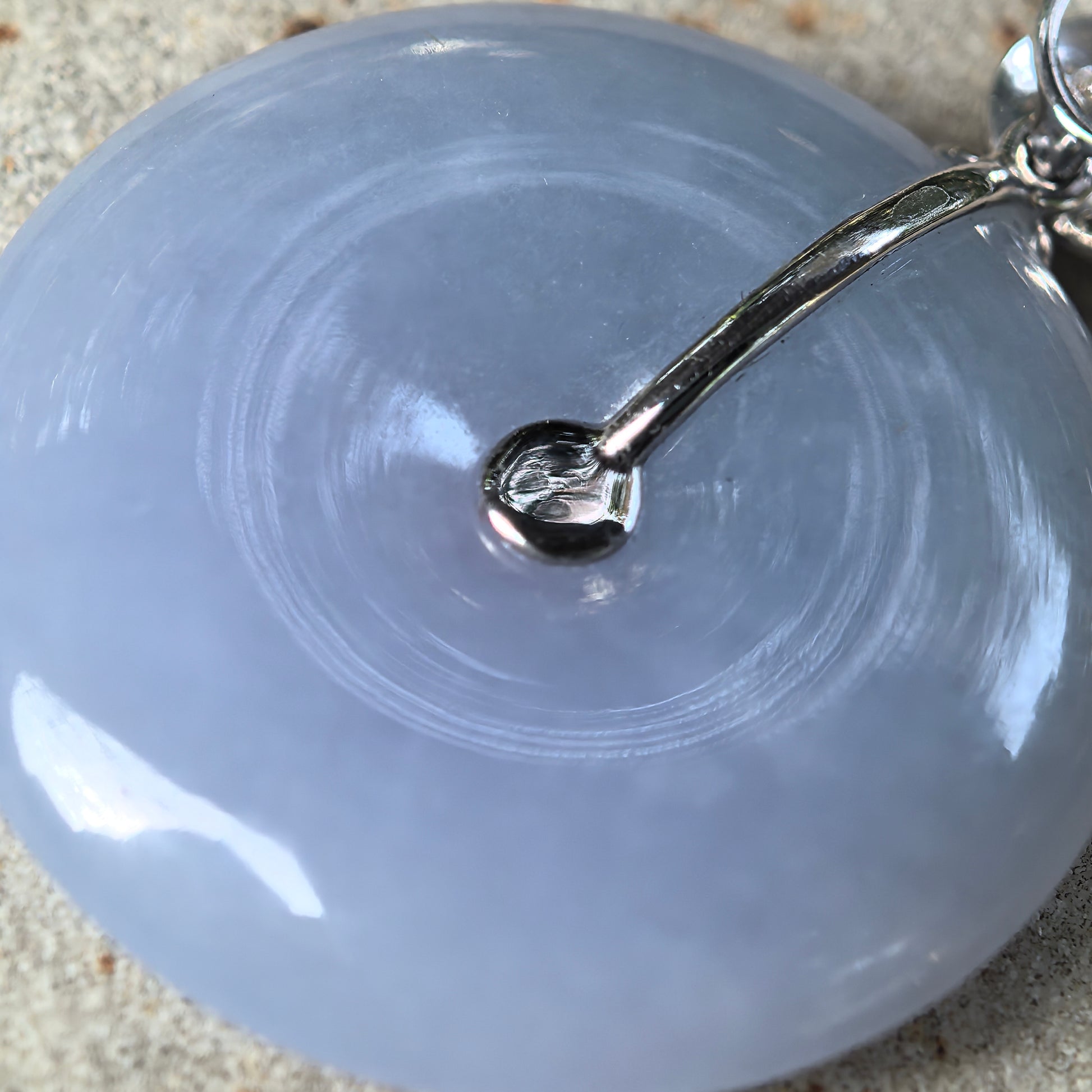 Macro detail of purple jadeite Peace Pendant showing delicate texture, soft translucency, and central accent stone.
