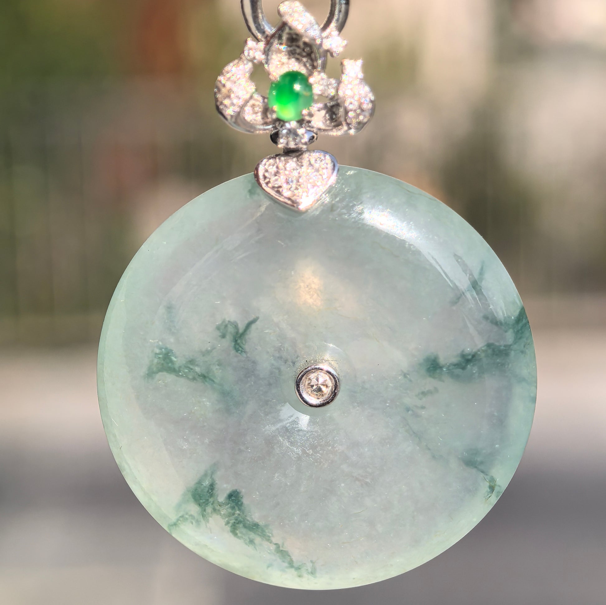 Front view of floating green jadeite Peace Pendant showing curved round surface, central opening, and gel-like luster.
