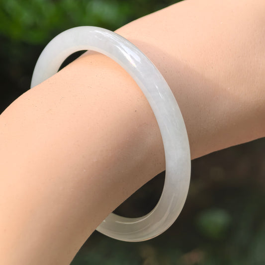 Natural Grade-A icy glutinous light green round jadeite bangle worn on the wrist with soft translucency.
