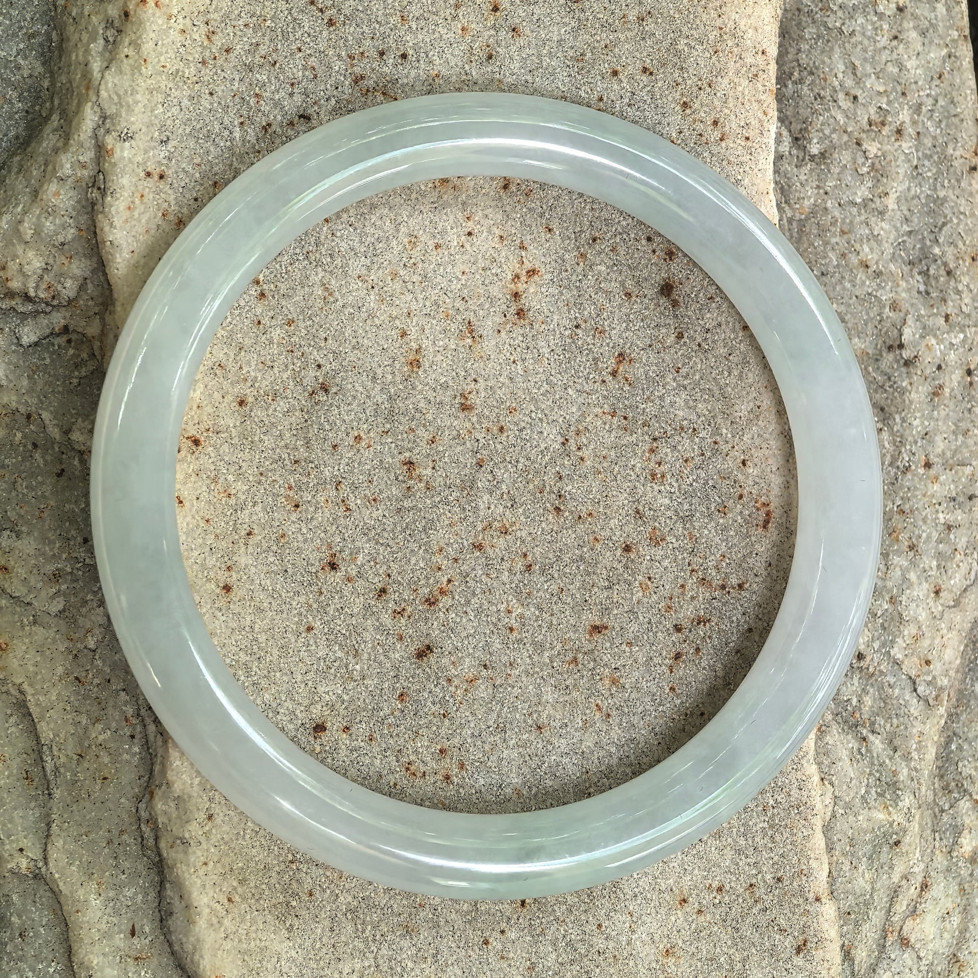 Top view of natural jadeite round bangle showing pale green tone and circular form.