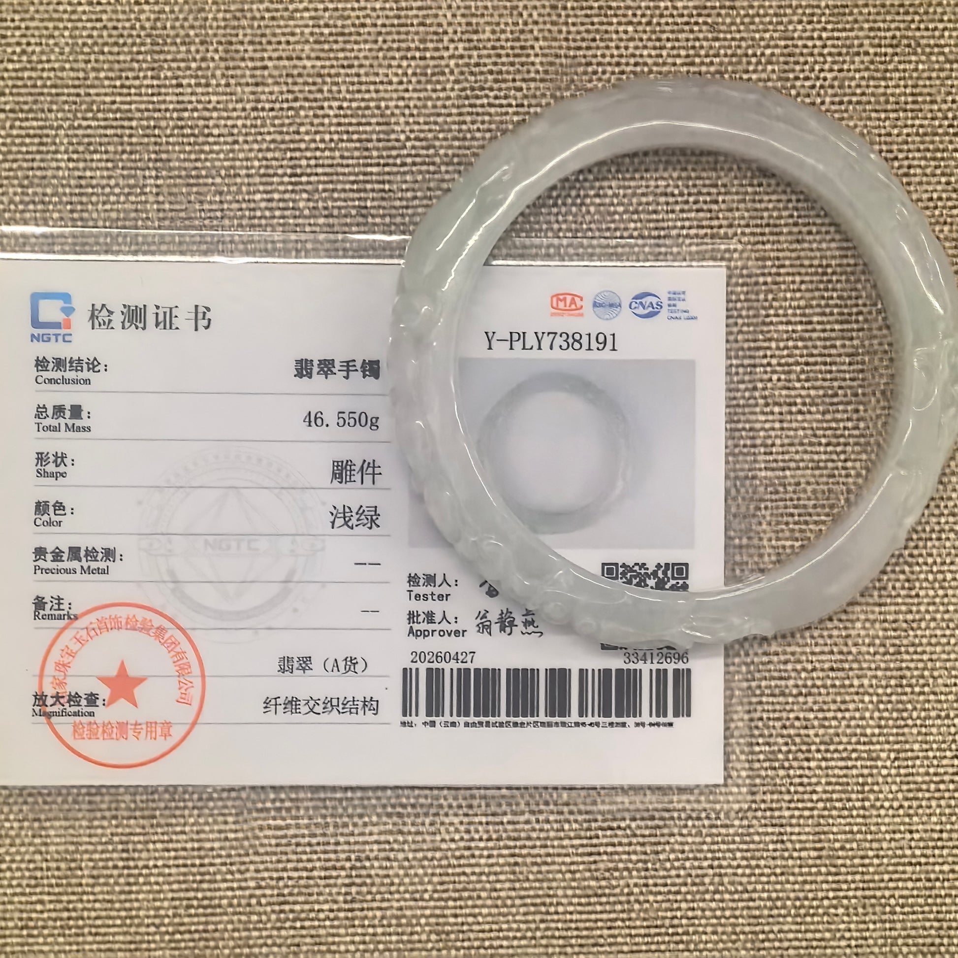 Natural Grade-A light green carved bat motif jadeite D-shape bangle shown with its matching NGTC certificate.