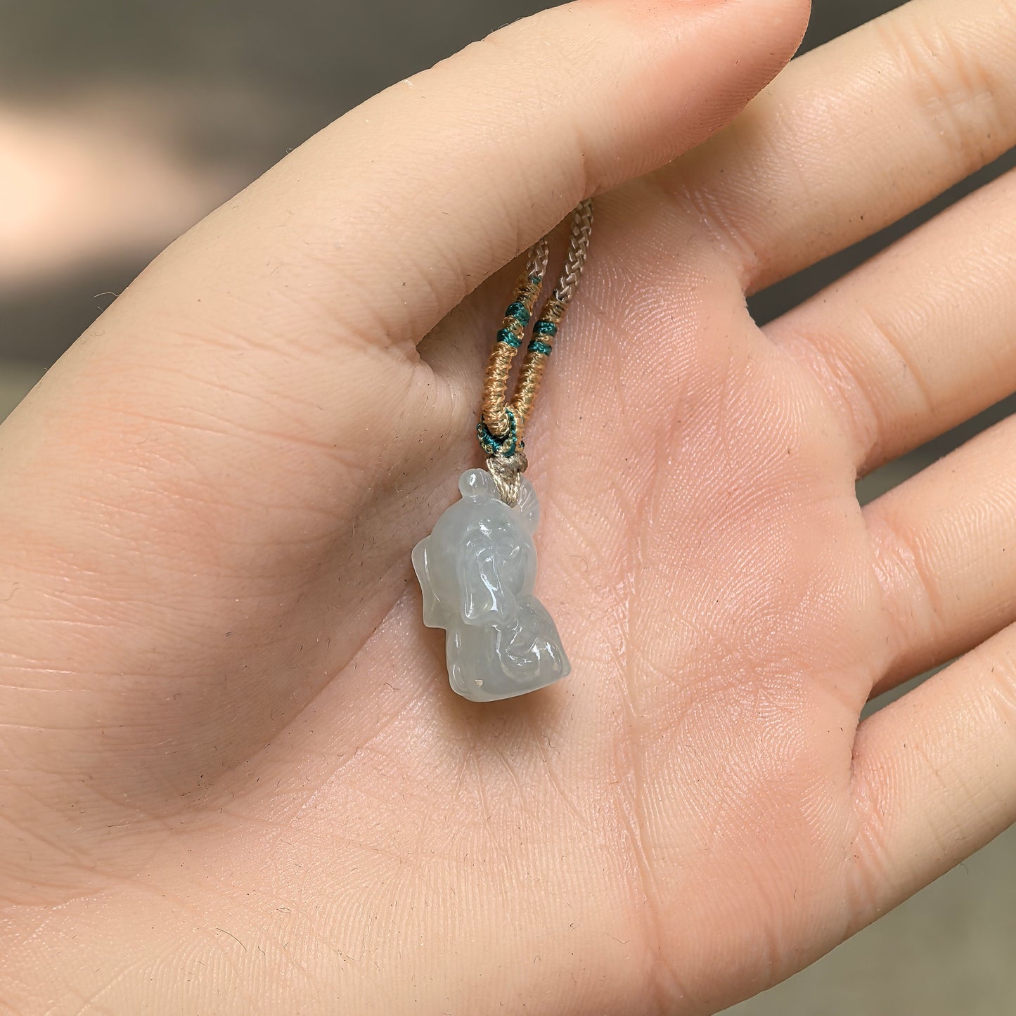 Natural Grade-A glutinous icy light green 3D elephant jadeite pendant shown in hand for size reference.