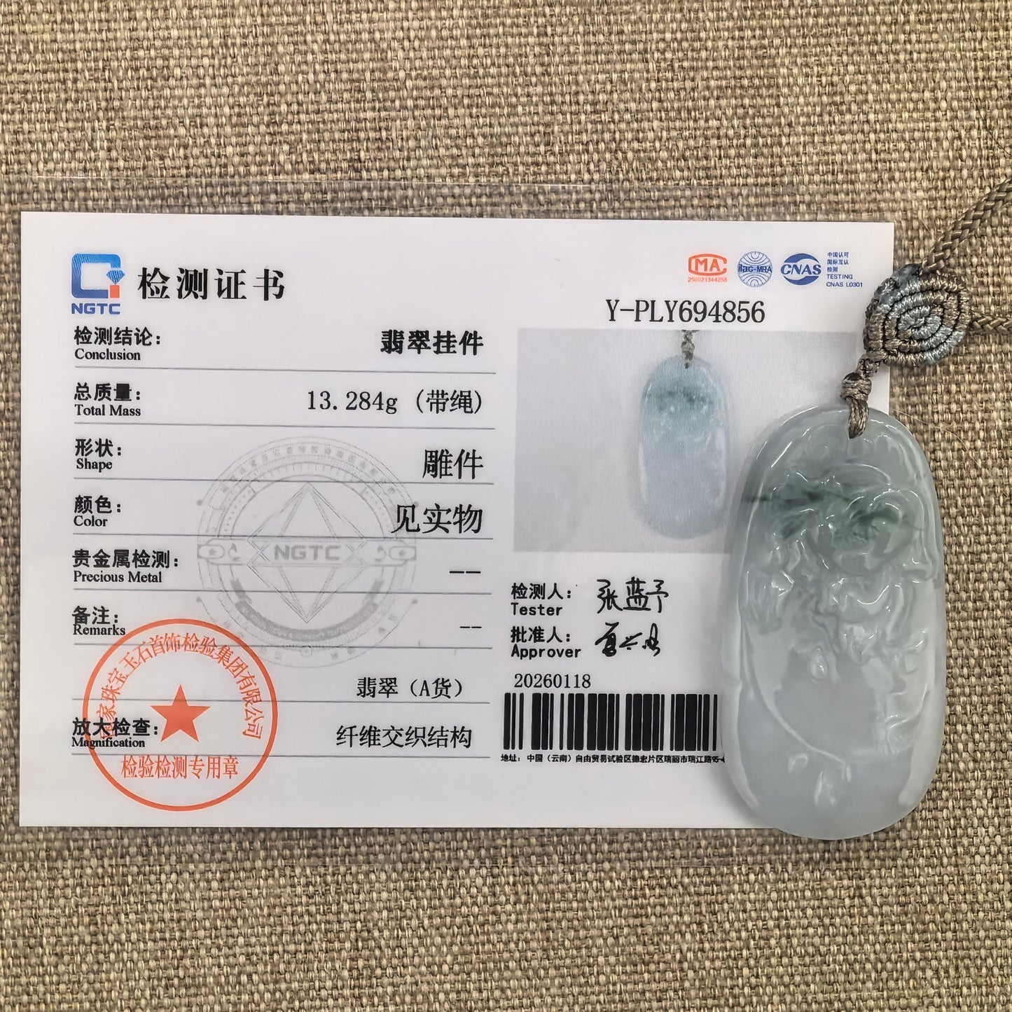 Natural Grade-A glutinous floating green carved jadeite pendant shown beside its matching NGTC certificate.