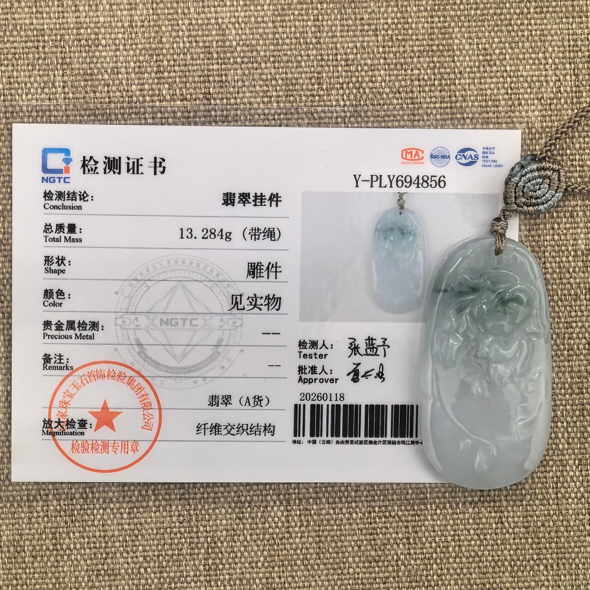 Natural Grade-A glutinous floating green carved jadeite pendant shown beside its matching NGTC certificate.