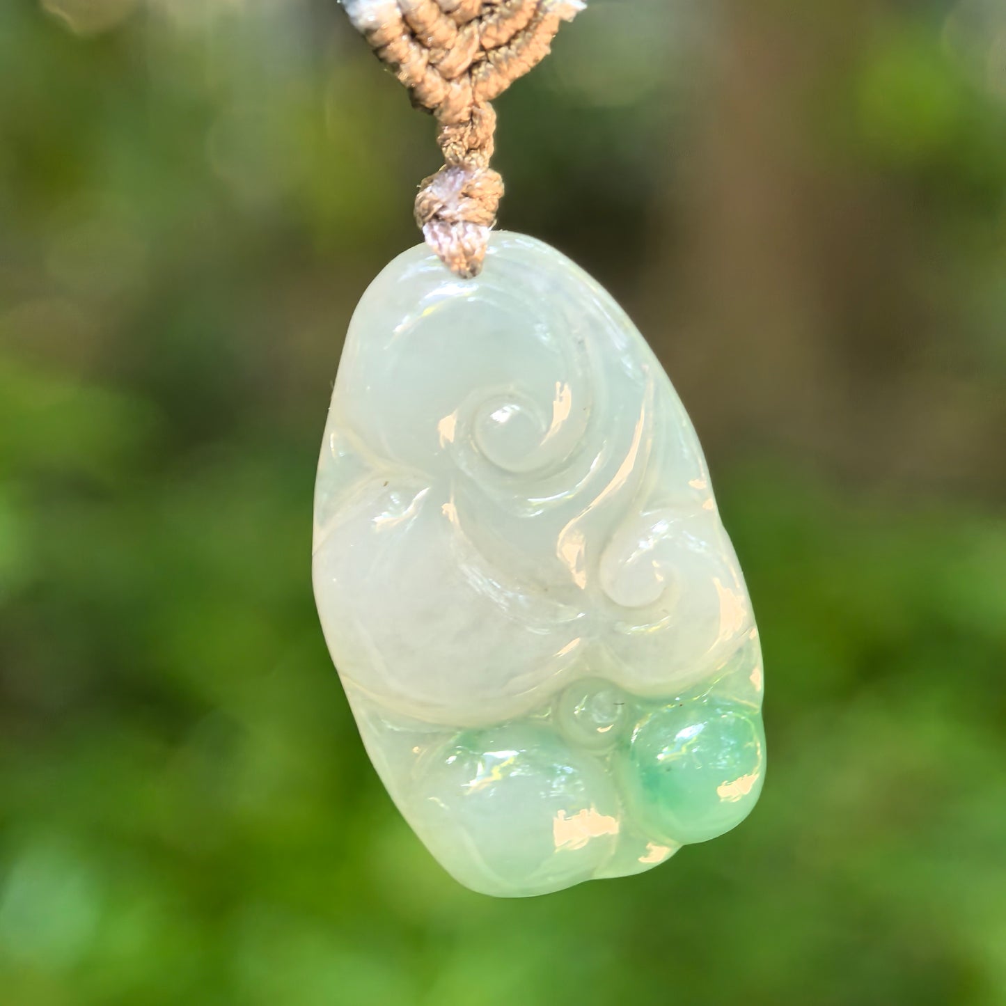 Natural Grade-A glutinous jadeite Ruyi pendant displayed with its matching cord.