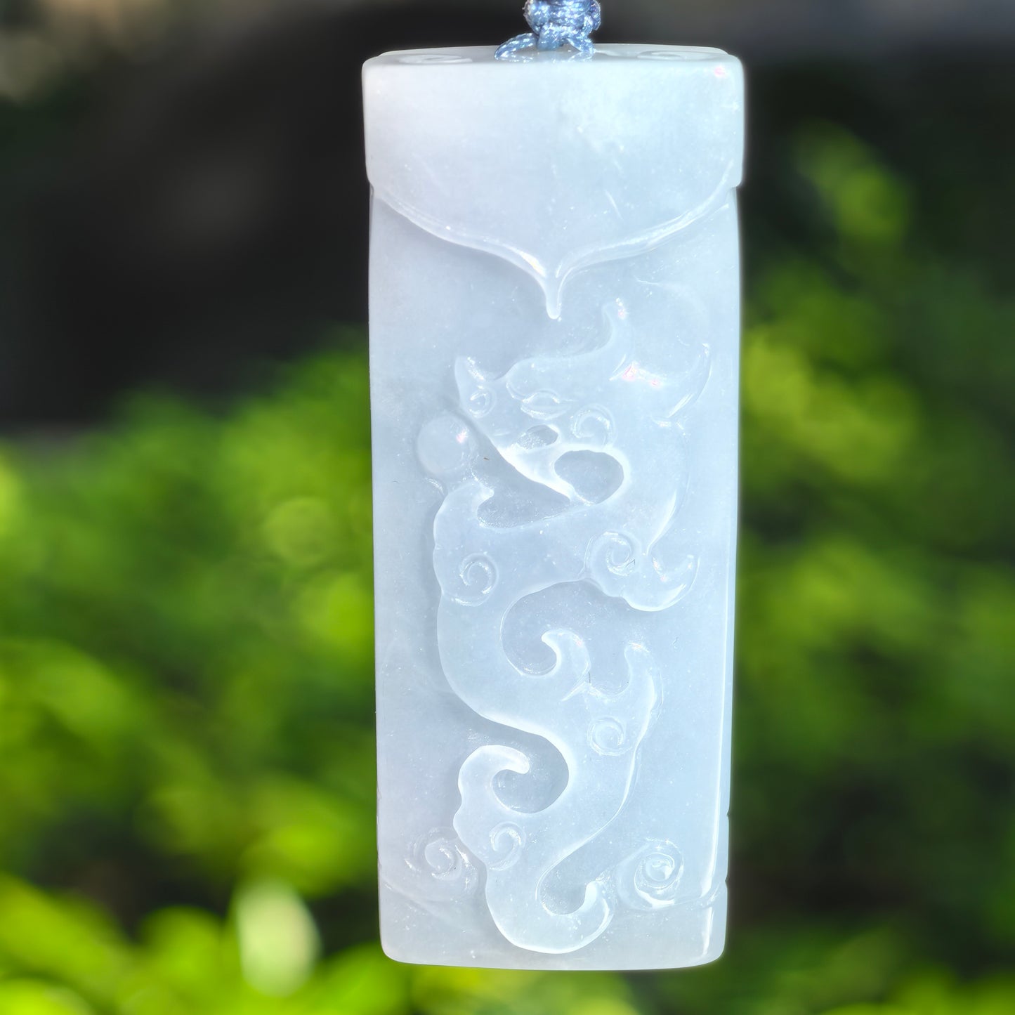 Natural Grade-A glutinous blue-lavender dragon jadeite pendant with thick rectangular plaque shape and carved dragon motif.