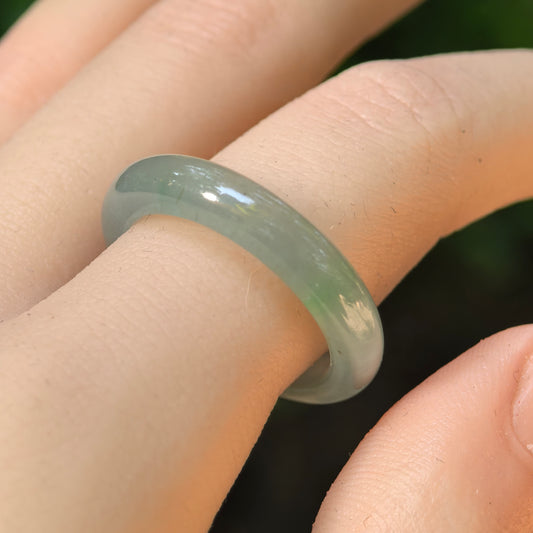 Natural Grade-A icy glutinous light green jadeite ring band worn on finger in natural light.