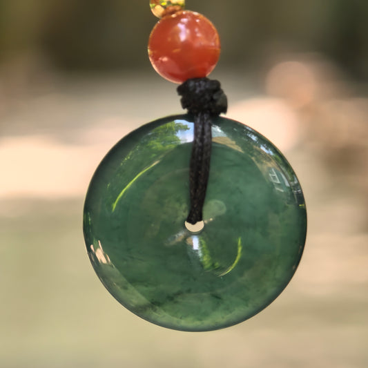 Natural Grade-A icy glutinous teal blue Guatemalan jadeite Peace Pendant hanging with black cord and red bead.
