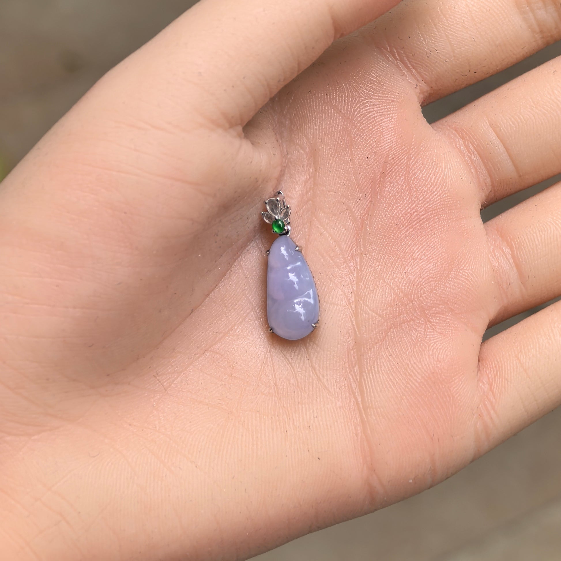 Handheld icy glutinous violet bean jadeite pendant showing small size, soft translucency, and green accent stone.