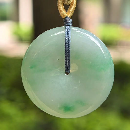 Natural Grade-A fine glutinous green Peace Pendant jadeite pendant hanging outdoors with cord.
