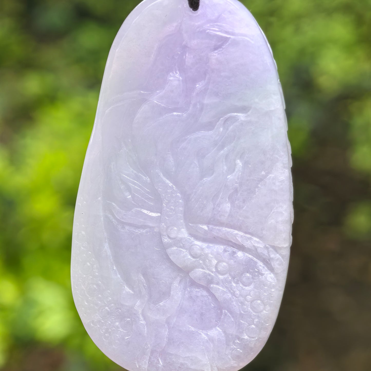 Back and side views of a light purple jadeite dragon pendant highlighting the carving depth and oval shape.