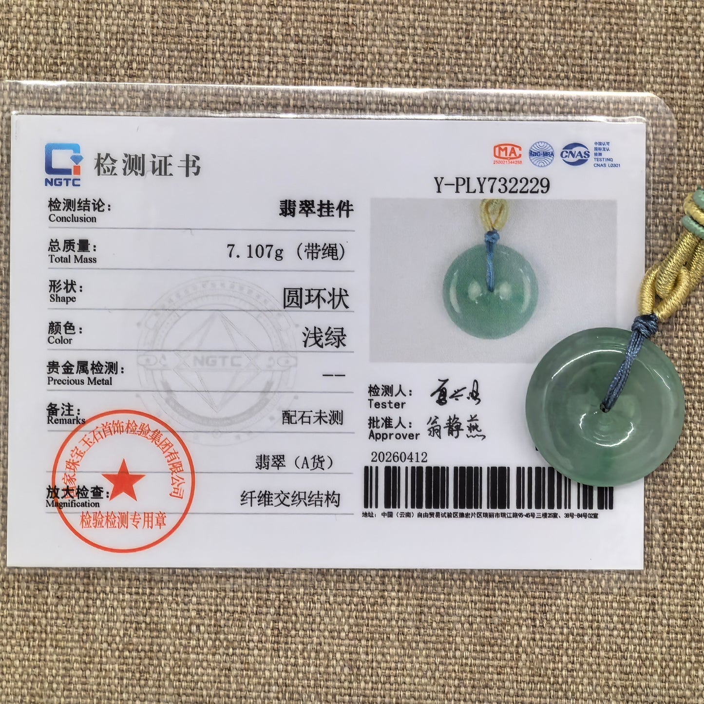 NGTC certified glutinous green Peace Pendant jadeite pendant shown with matching certificate and cord.
