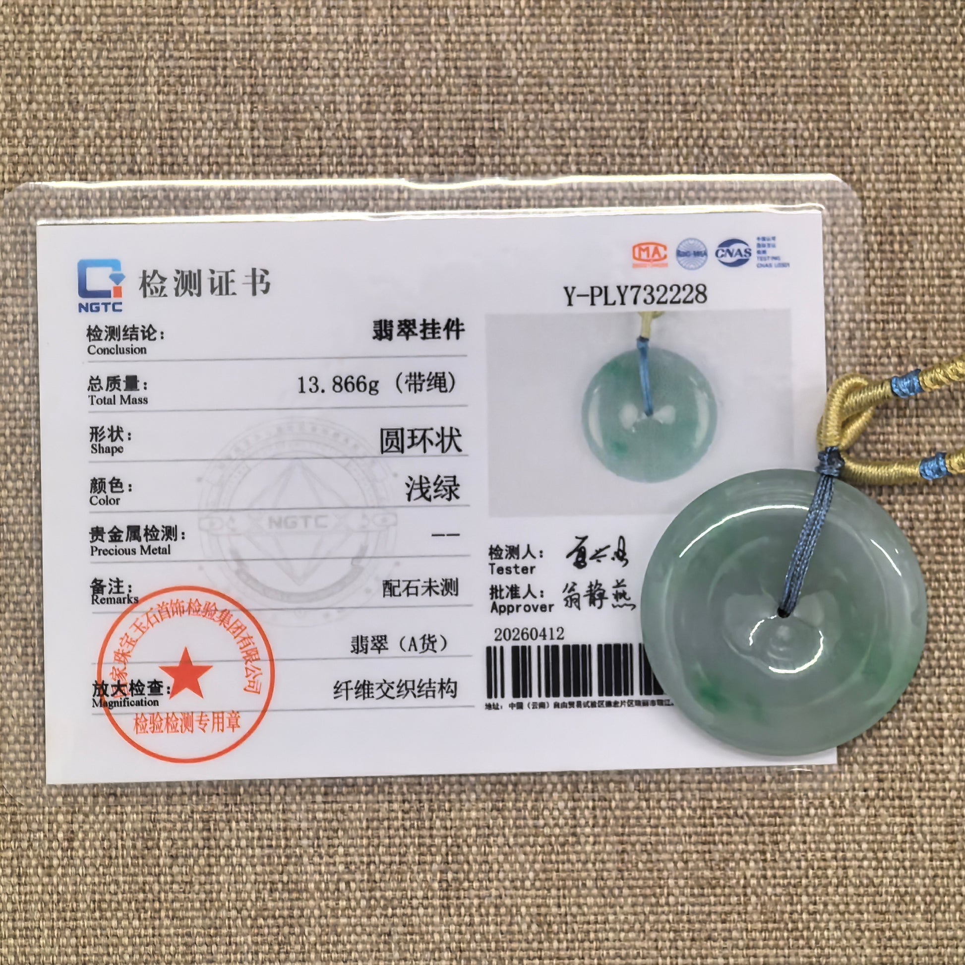 NGTC certified fine glutinous green Peace Pendant jadeite pendant shown with matching certificate and cord.