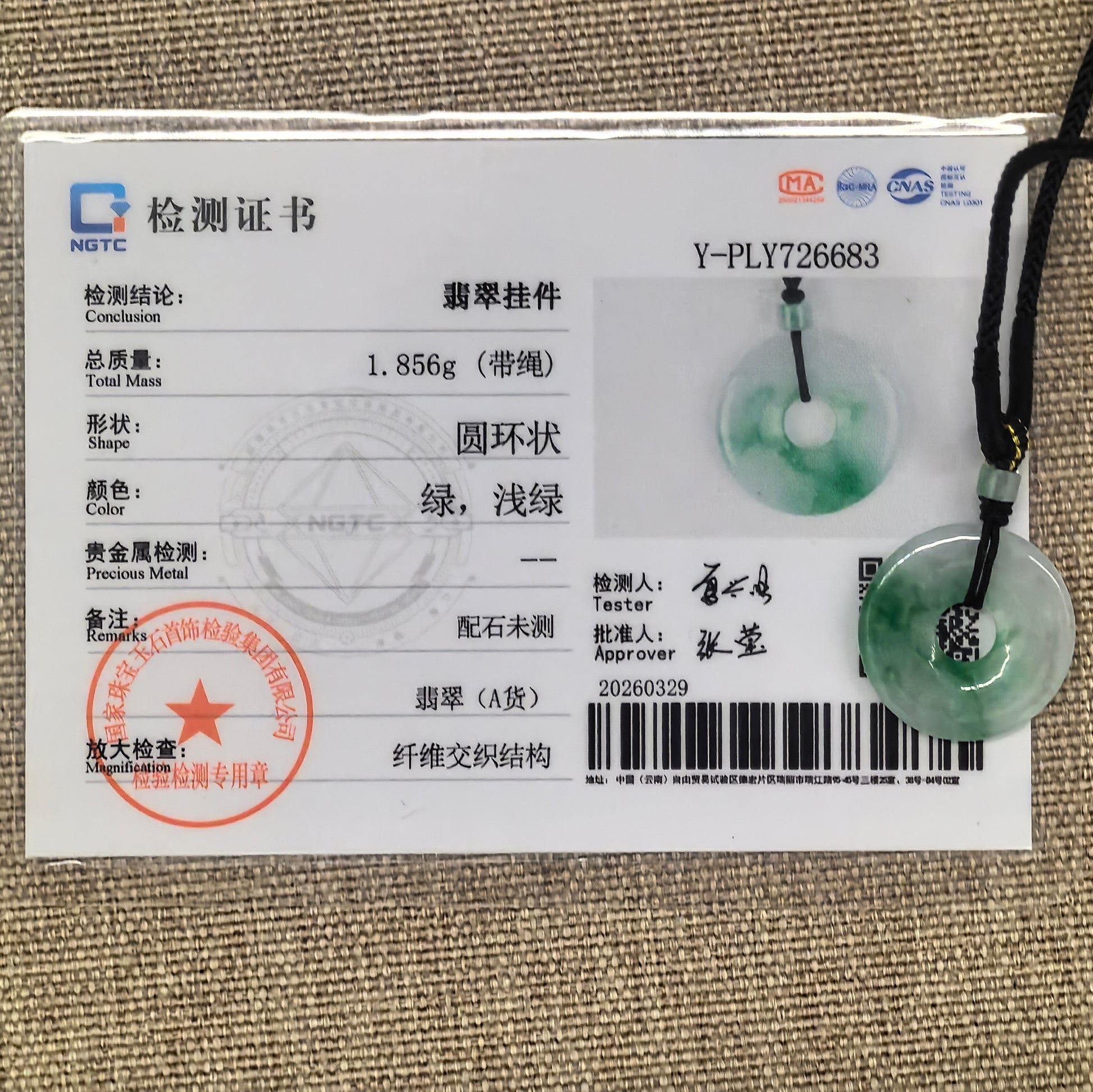NGTC certified white-based green donut jadeite pendant shown with matching certificate and cord.