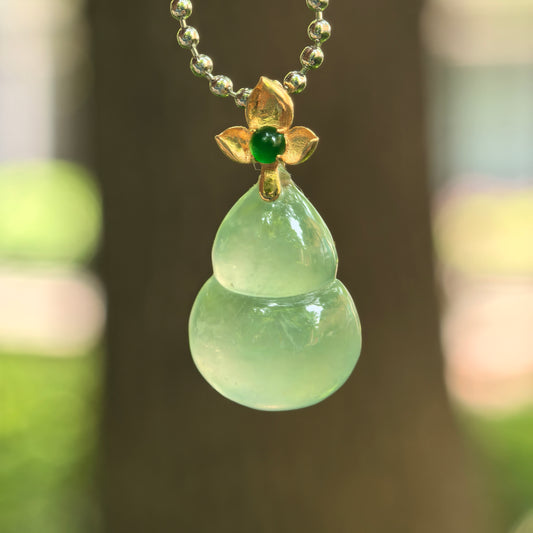 Natural Grade-A icy light green gourd jadeite pendant with 18K gold floral bail.
