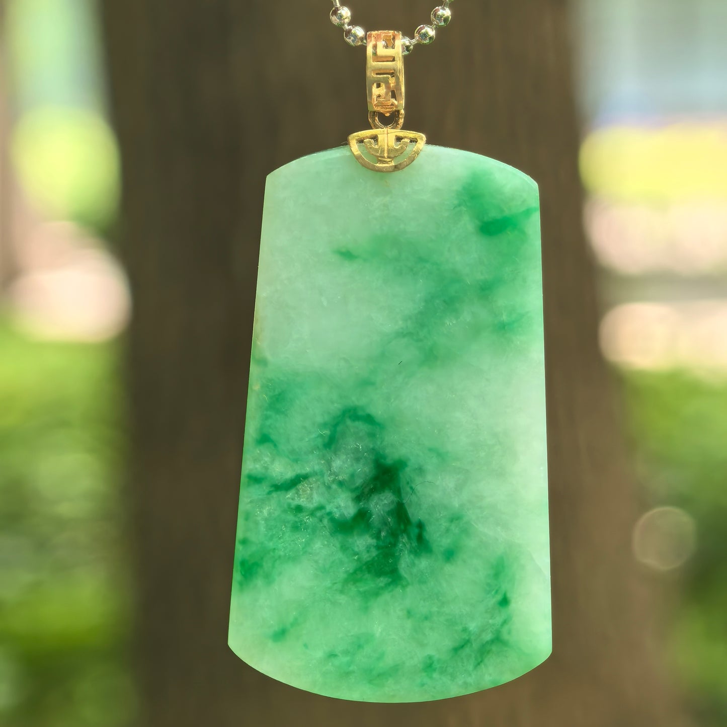 Natural Grade-A glutinous light green plain jade plaque pendant with floating green patterns and 18K gold bail.
