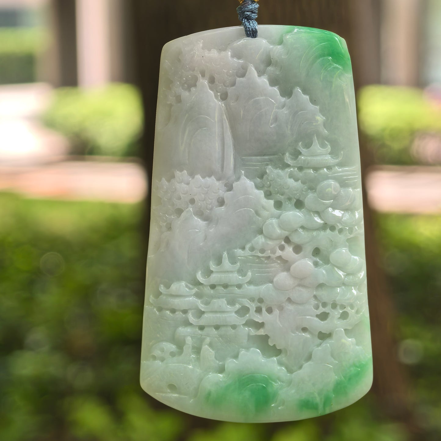 Natural Grade-A glutinous white-base green landscape jadeite plaque pendant hanging on cord.
