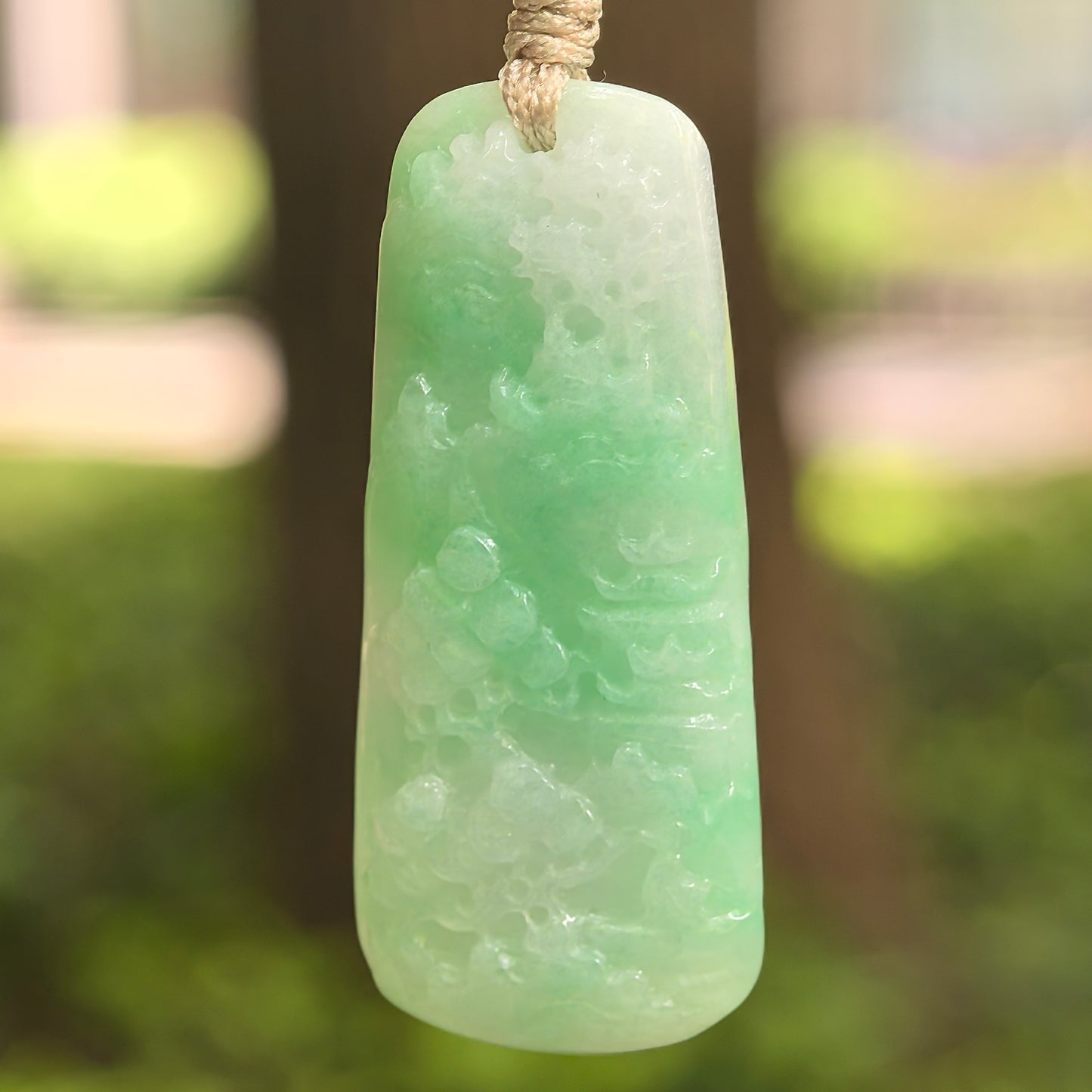 Natural Grade-A glutinous white-base green landscape jadeite plaque pendant hanging on cord.
