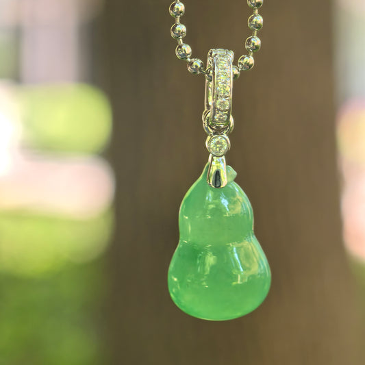 Natural Grade-A icy vivid green gourd jadeite pendant with 18K gold bail hanging on chain.

