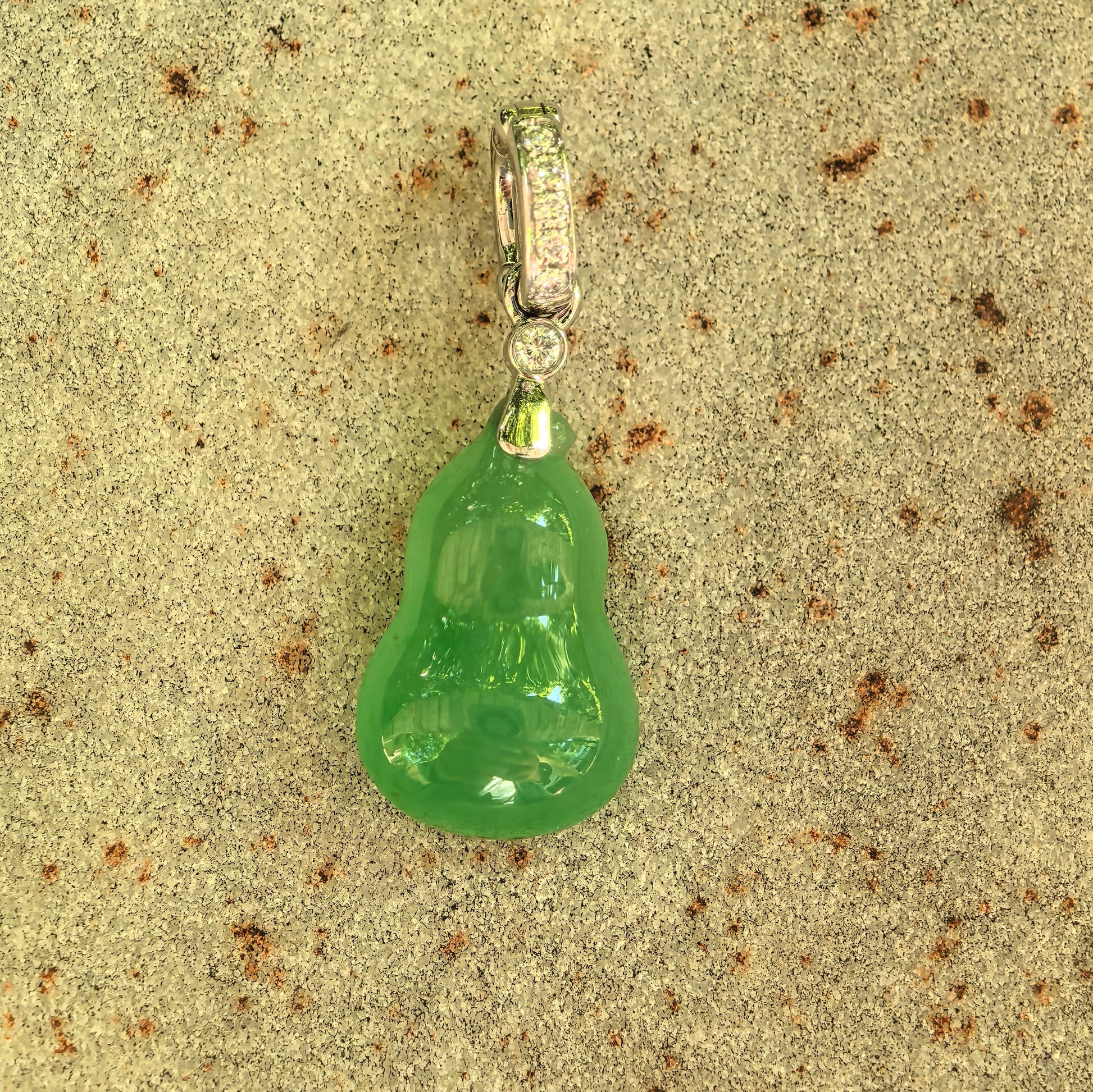 Close-up of icy green gourd jadeite pendant showing glossy carving and saturated color.
