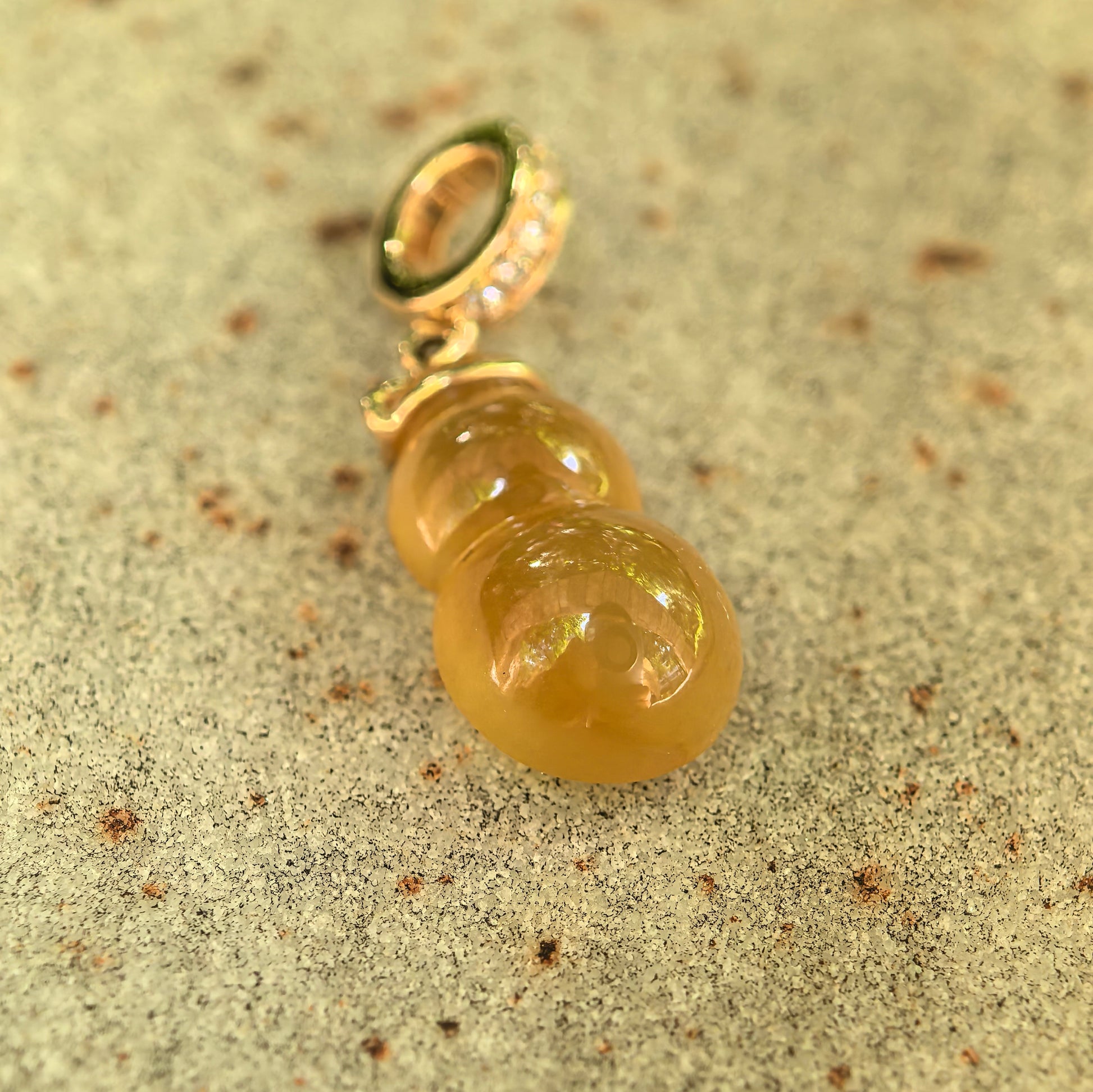 Close-up of icy translucent yellow gourd jadeite pendant showing clean interior and glossy surface.

