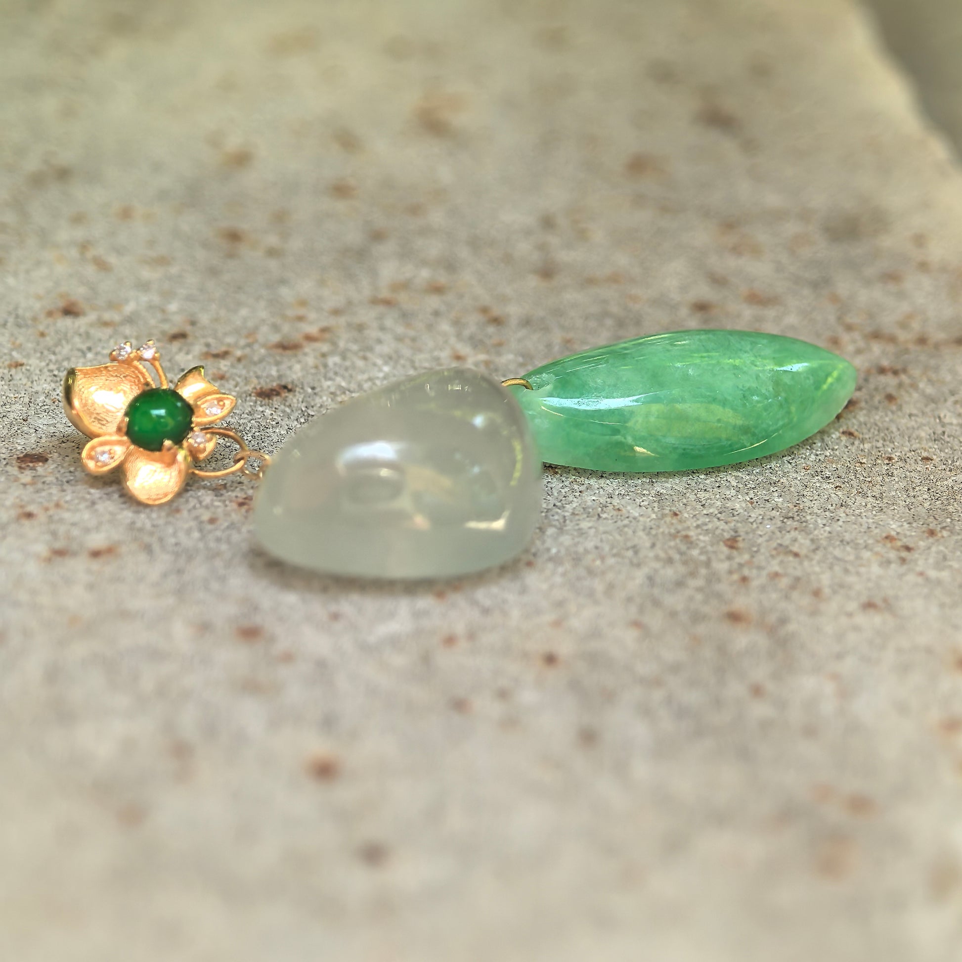 Side view of glutinous icy white heart jadeite and green water-drop jadeite pendant showing smooth cabochon polish.