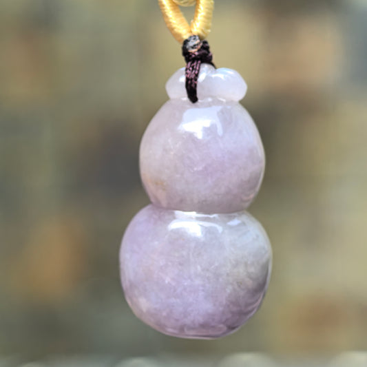 Close-up of lavender gourd jadeite pendant showing rounded three-dimensional carving and soft luster.
