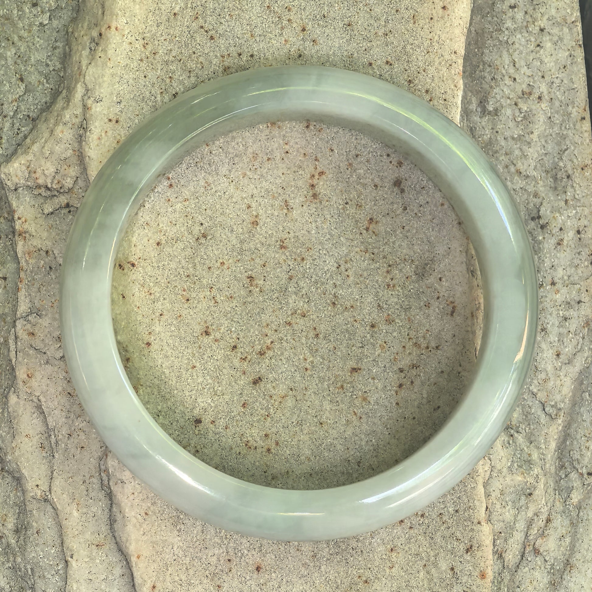 Another top view of fine glutinous light green jadeite bangle showing natural texture.
