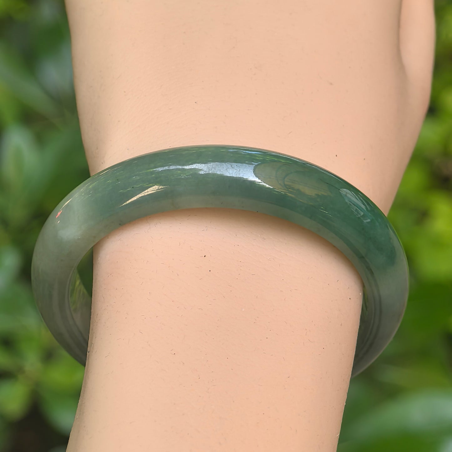 Fine glutinous green Burmese jadeite bangle with natural cotton-like cloud patches.
