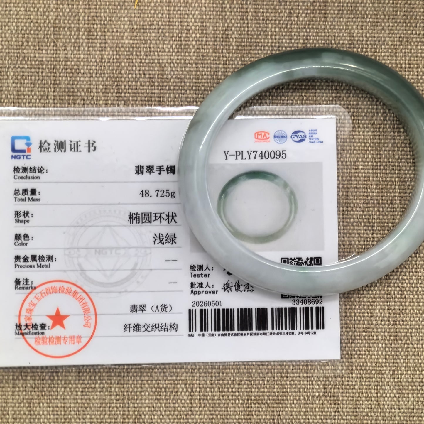 NGTC certified white and light green oval jadeite bangle shown with matching certificate.