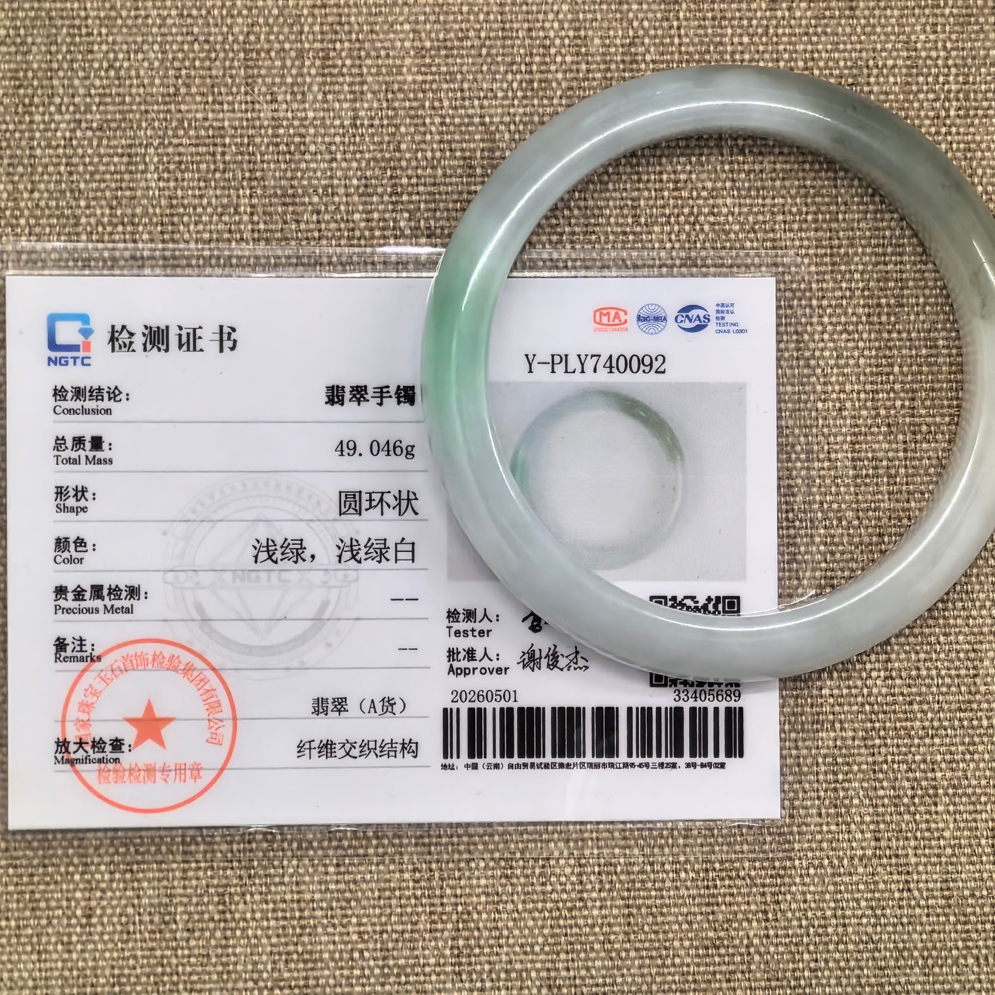 NGTC certified natural Grade-A white-based green jadeite bangle shown with matching certificate.