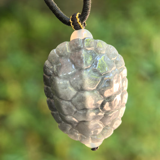 Natural Grade-A glutinous gray-black turtle shell jadeite pendant hanging on black cord with raised shell carving.
