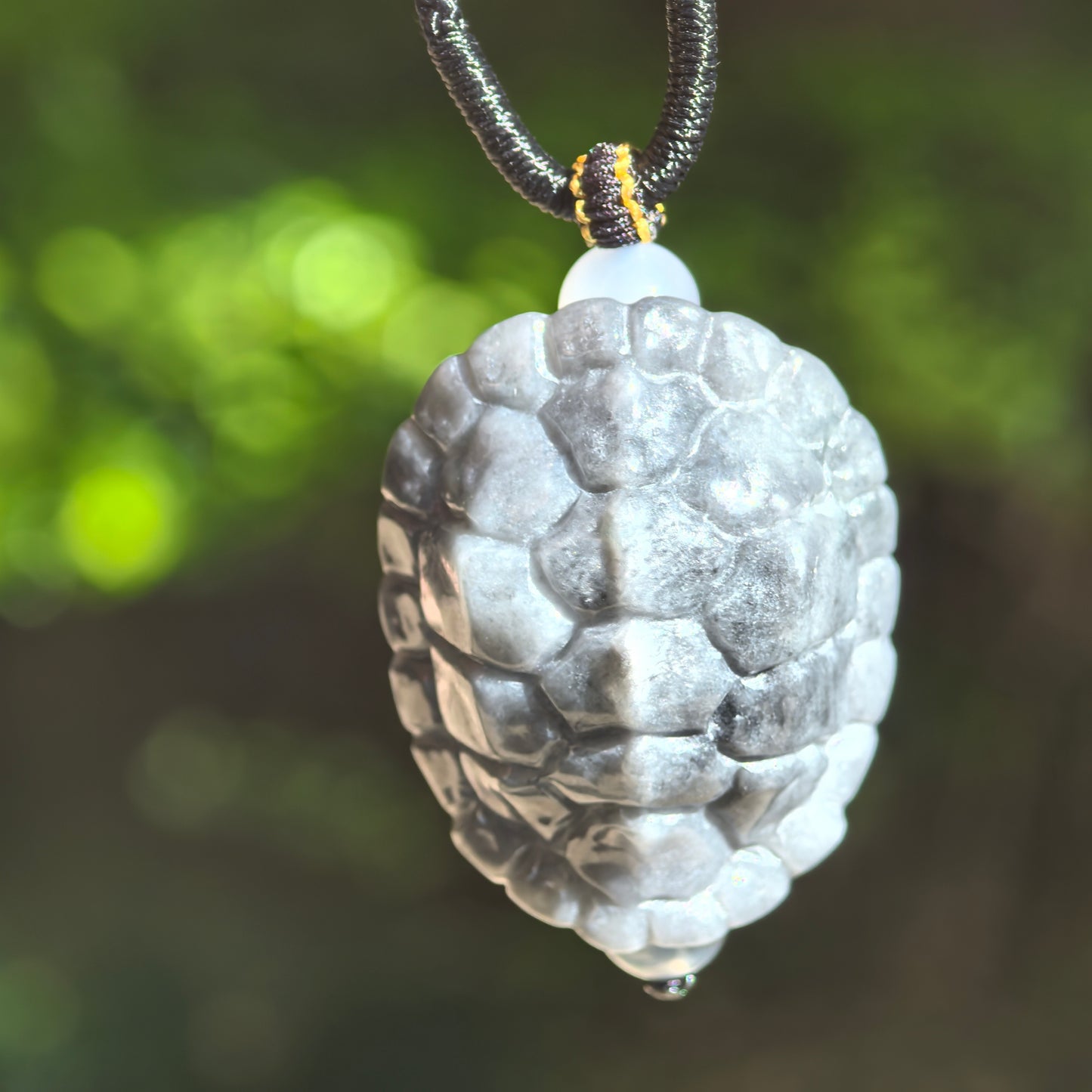 Close-up of gray-black turtle shell jadeite pendant showing rounded three-dimensional shell texture and polished surface.

