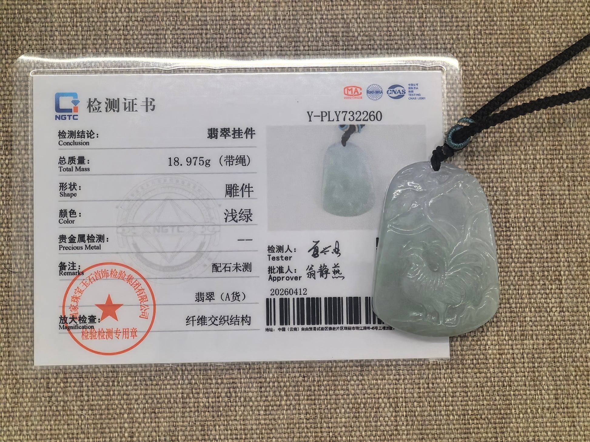 NGTC certified glutinous light green rooster jadeite pendant shown with matching certificate.