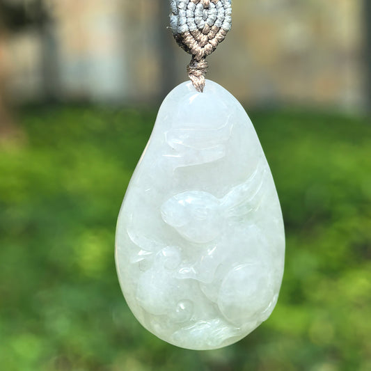 Natural Grade-A glutinous white rabbit jadeite pendant hanging on cord with soft translucent glow.
