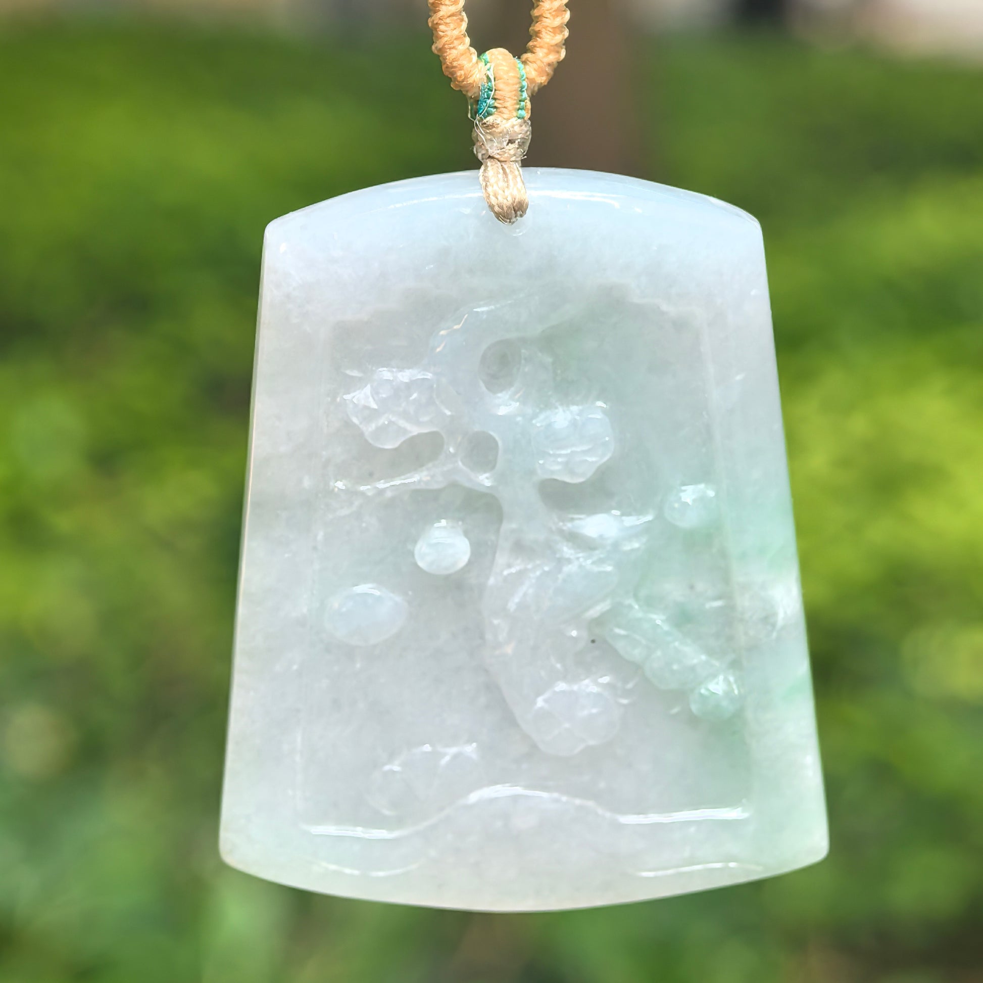 Natural Grade-A glutinous white-green floral carved jadeite pendant hanging on cord.
